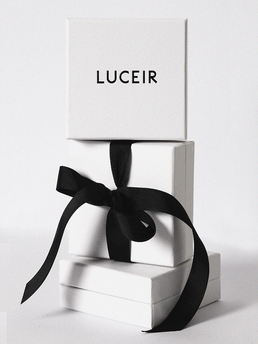 Three Luceir logo'd white boxes stacked upon each other with a black ribbon tied around the central box
